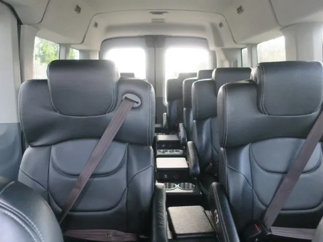 Leather captain’s seats with cup holders inside the 10-passenger Ford Transit
